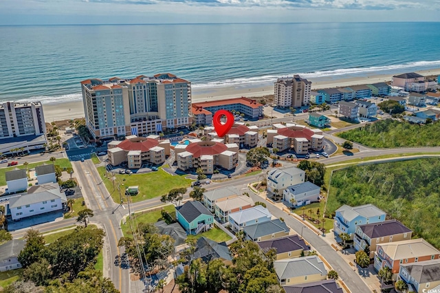 birds eye view of property with a water view and a view of the beach