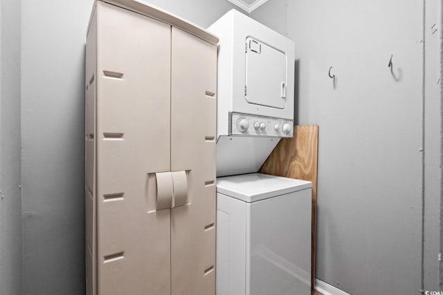 washroom featuring stacked washer / dryer and ornamental molding