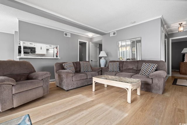 living room featuring light wood-type flooring and ornamental molding