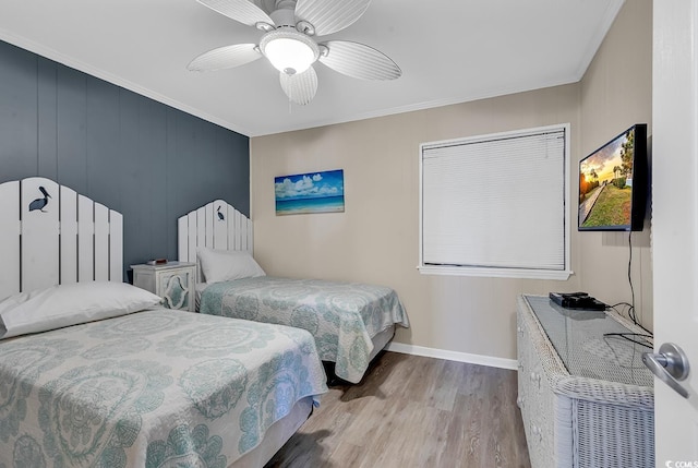 bedroom with light wood-type flooring, ceiling fan, and crown molding