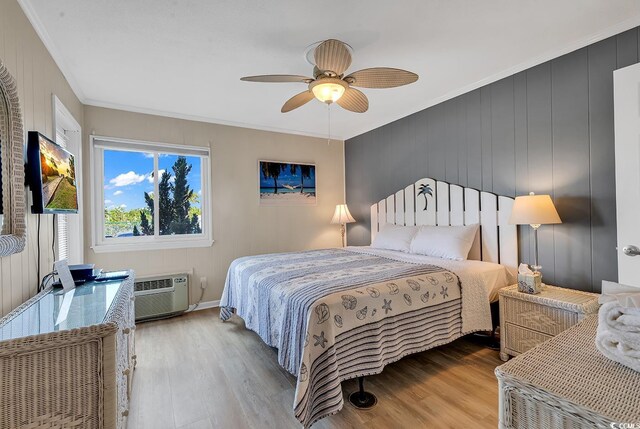 bedroom with an AC wall unit, light hardwood / wood-style flooring, ceiling fan, and crown molding