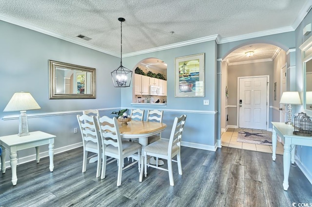 dining area featuring a textured ceiling, crown molding, and dark wood-type flooring