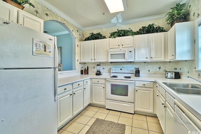 kitchen featuring sink, white appliances, white cabinetry, and light tile patterned flooring