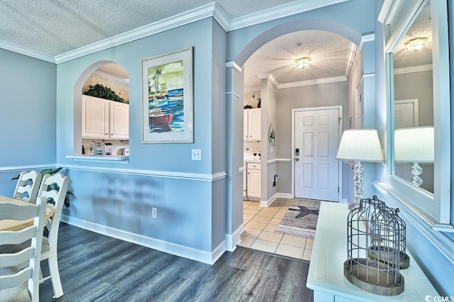 entrance foyer featuring crown molding, wood-type flooring, and a textured ceiling