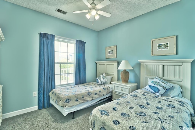 bedroom featuring ceiling fan, carpet floors, and a textured ceiling