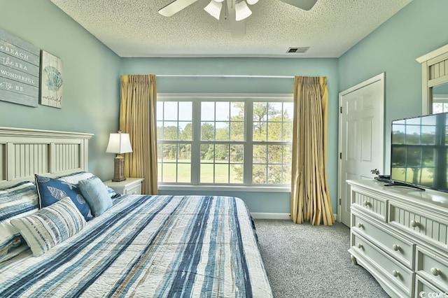 carpeted bedroom with ceiling fan and a textured ceiling