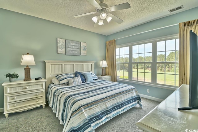 carpeted bedroom featuring ceiling fan and a textured ceiling