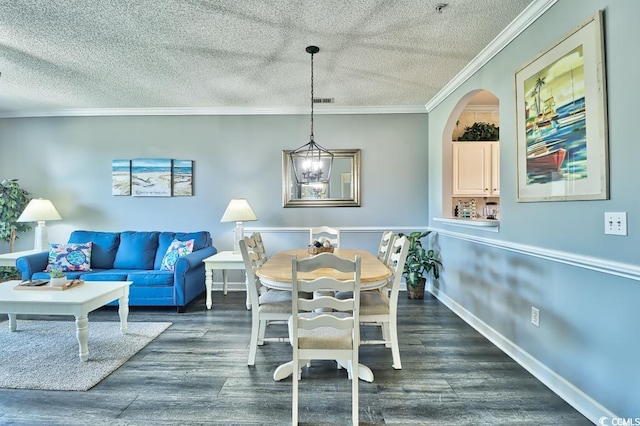 dining area with a chandelier, a textured ceiling, and ornamental molding