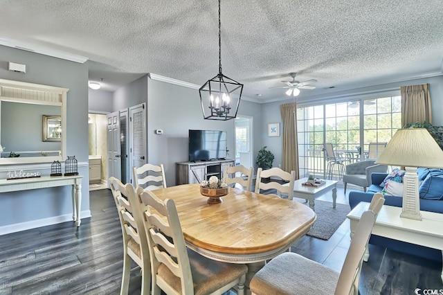 dining area with a textured ceiling, ceiling fan with notable chandelier, crown molding, and dark wood-type flooring