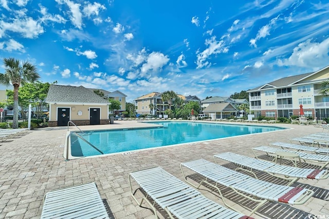 view of swimming pool featuring an outbuilding and a patio