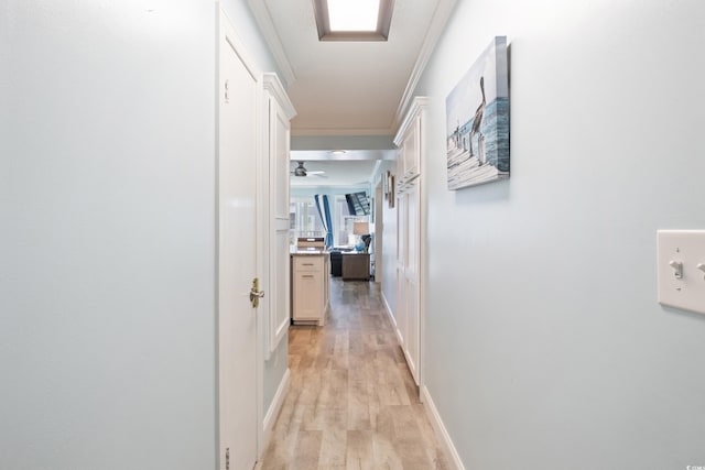 hall featuring light wood-type flooring and ornamental molding