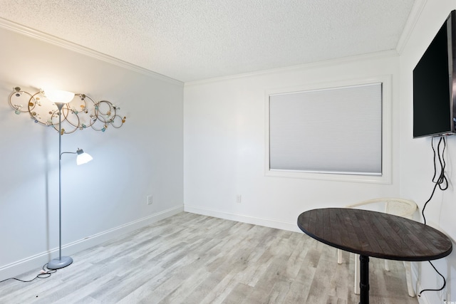 living area featuring light wood-type flooring, a textured ceiling, and ornamental molding