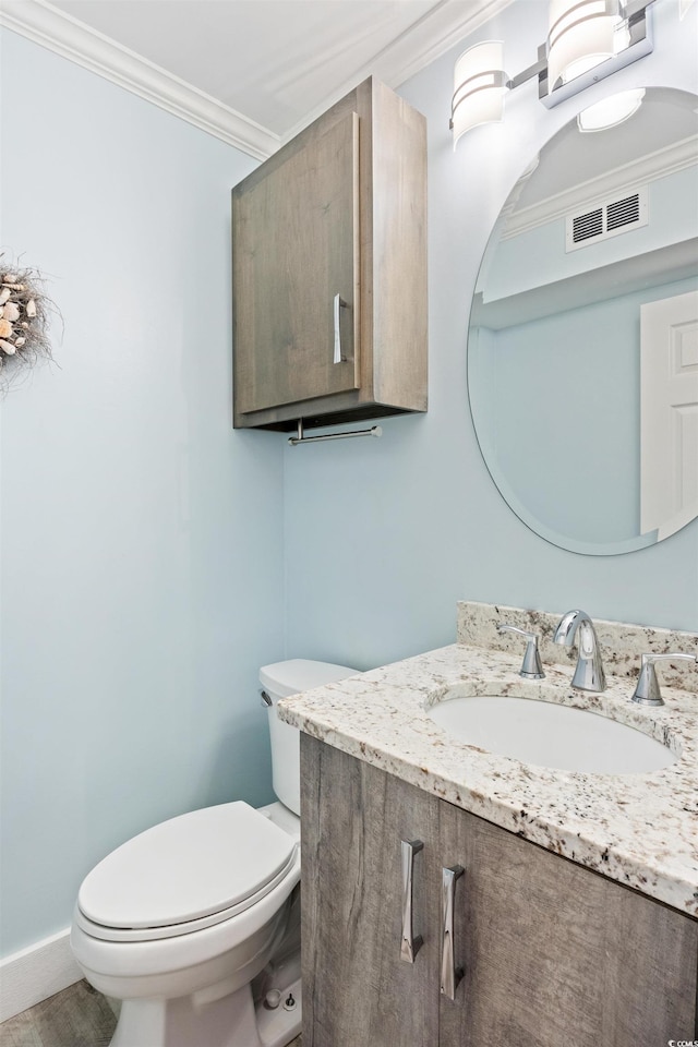 bathroom featuring crown molding, vanity, and toilet