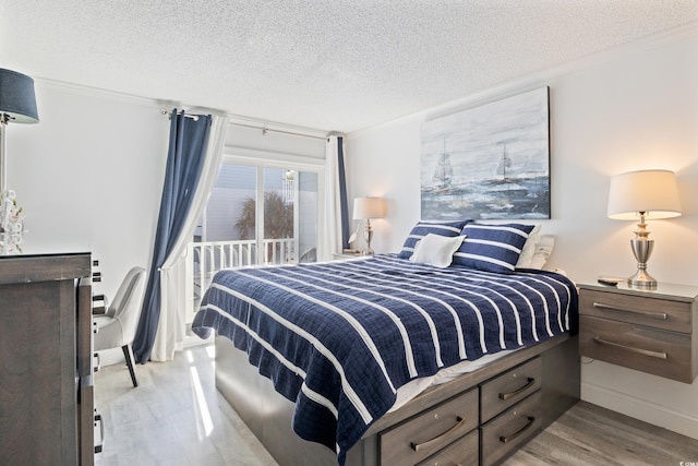 bedroom with crown molding, a textured ceiling, and light wood-type flooring