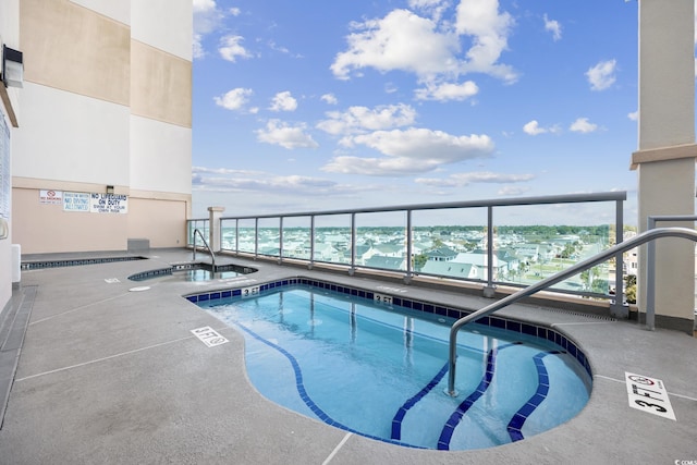 view of swimming pool featuring sink and a hot tub