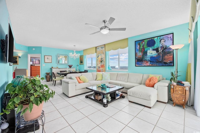 living room featuring ceiling fan with notable chandelier, light tile patterned flooring, and a textured ceiling