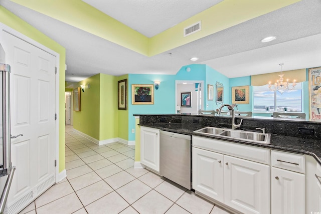 kitchen with dark stone counters, sink, dishwasher, a chandelier, and white cabinetry