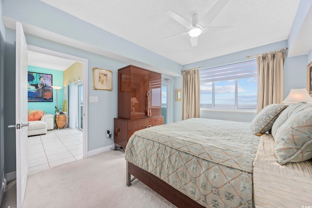 bedroom featuring ceiling fan, light carpet, and a textured ceiling