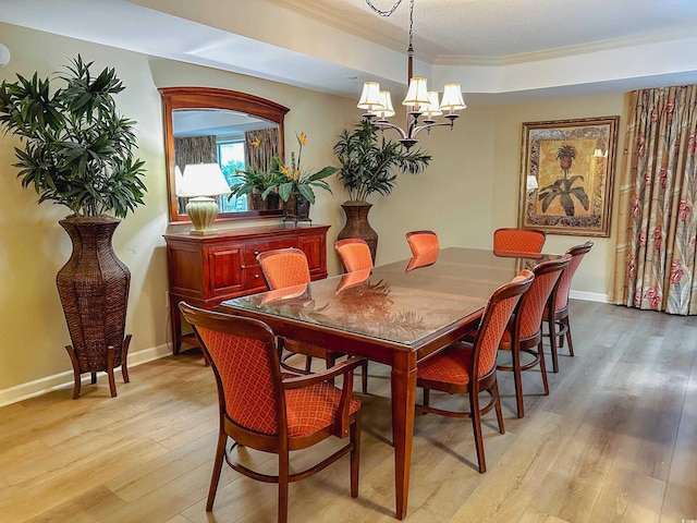 dining area featuring a notable chandelier, light wood-type flooring, and ornamental molding