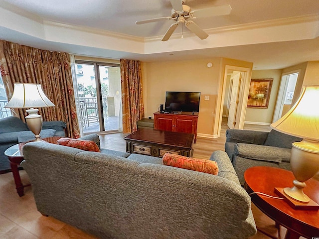 living room with ceiling fan, ornamental molding, and a tray ceiling