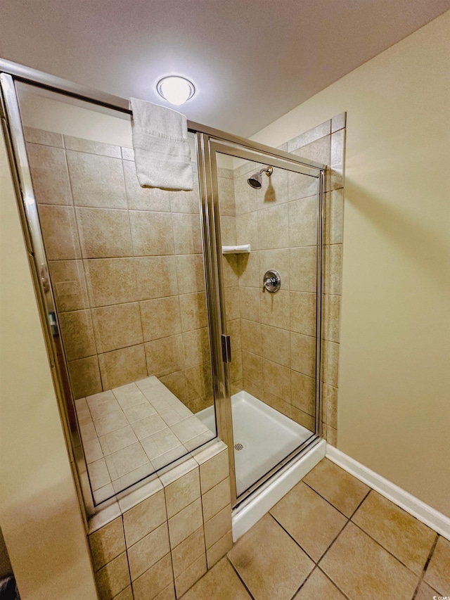 bathroom with tile patterned floors and a shower with door