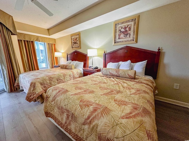 bedroom with a textured ceiling, hardwood / wood-style flooring, and ceiling fan