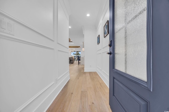 hall featuring light hardwood / wood-style floors and ornamental molding