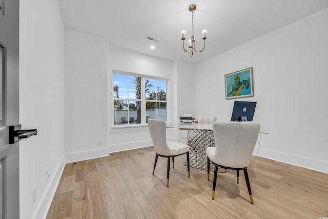 dining room with a chandelier and light wood-type flooring