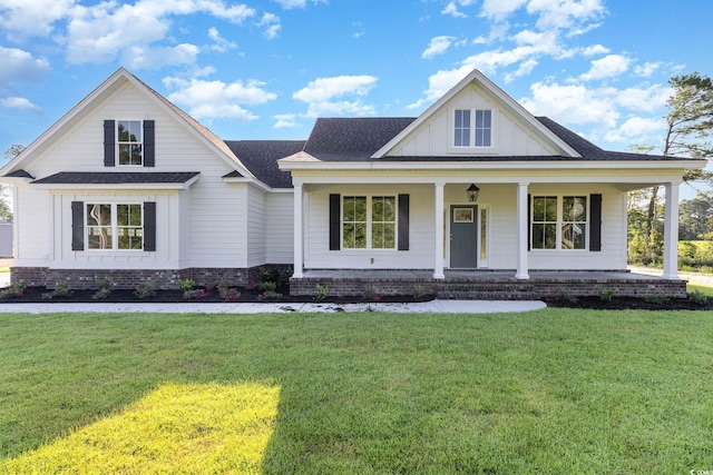 view of front of home with covered porch and a front lawn