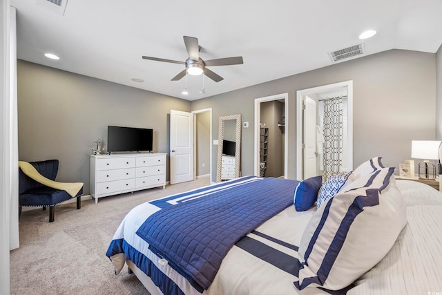 carpeted bedroom with a spacious closet, a closet, ceiling fan, and vaulted ceiling