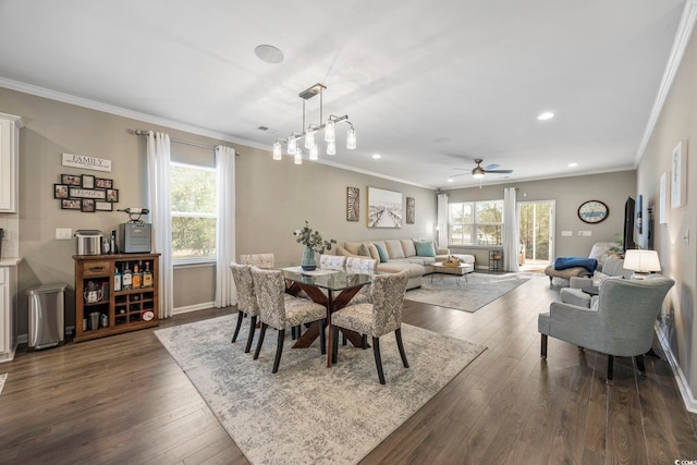 dining space featuring dark hardwood / wood-style floors, crown molding, and a healthy amount of sunlight