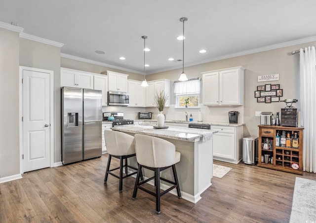 kitchen featuring white cabinets, pendant lighting, a center island, and stainless steel appliances