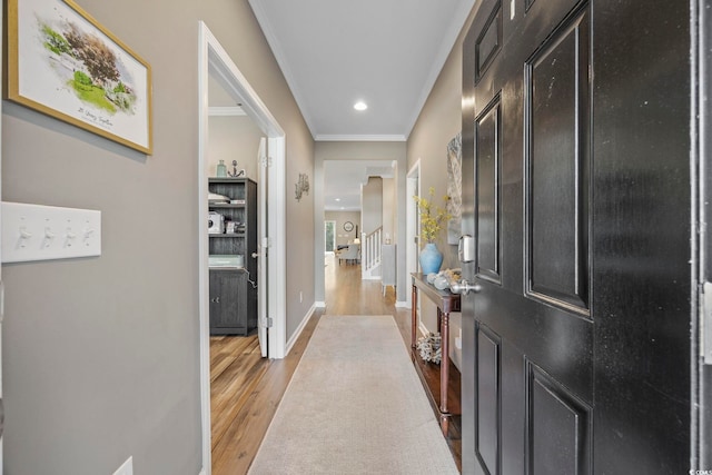 hallway featuring light hardwood / wood-style floors and crown molding