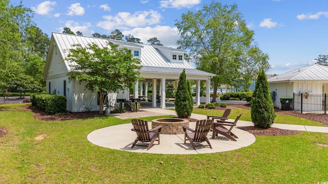 rear view of house with a patio area, a yard, and a fire pit