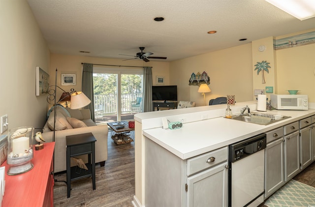 kitchen with a textured ceiling, white appliances, sink, gray cabinets, and dark hardwood / wood-style floors