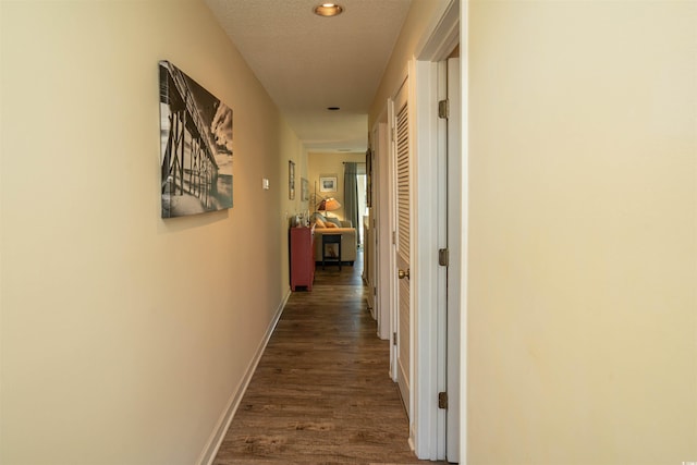 hall featuring dark hardwood / wood-style flooring and a textured ceiling