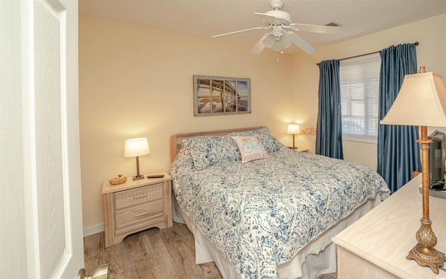 bedroom with ceiling fan and light hardwood / wood-style flooring