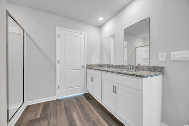 bathroom with vanity, hardwood / wood-style flooring, and a shower with shower door