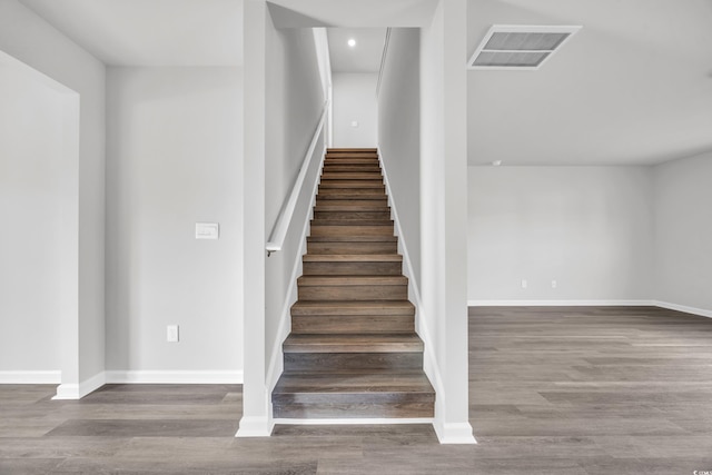 staircase with hardwood / wood-style floors