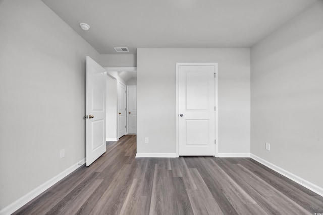 unfurnished bedroom with dark hardwood / wood-style flooring