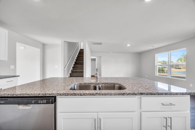 kitchen with dishwasher, white cabinets, light stone counters, and sink