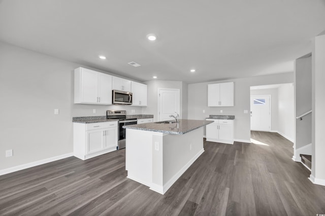 kitchen featuring a kitchen island with sink, white cabinets, and appliances with stainless steel finishes