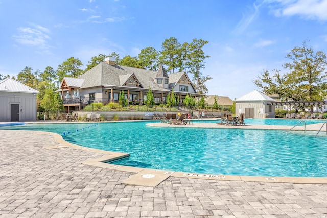 view of swimming pool with an outbuilding and a patio area