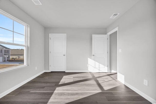 unfurnished bedroom with dark hardwood / wood-style floors