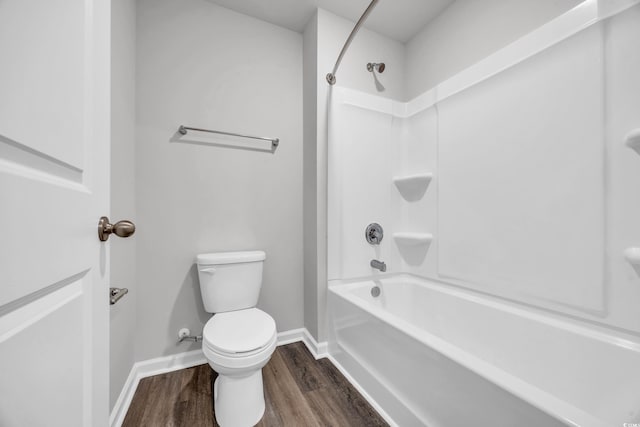 bathroom featuring hardwood / wood-style flooring, toilet, and shower / washtub combination