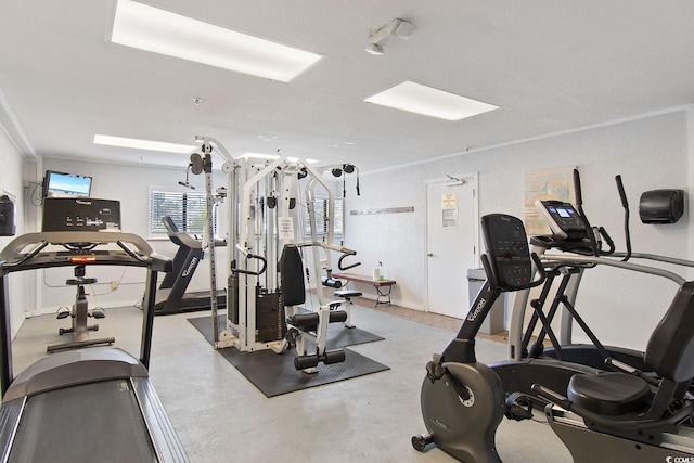 workout area featuring crown molding