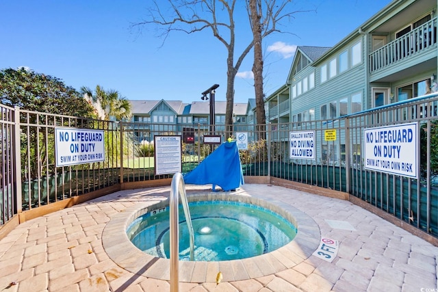 view of swimming pool featuring a hot tub