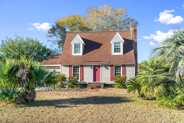 702 Plantation Dr, Surfside Beach, SC 29575 - cape cod house featuring a chimney and a front lawn