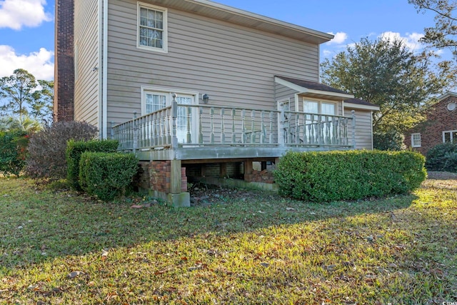 back of house with a deck and a yard