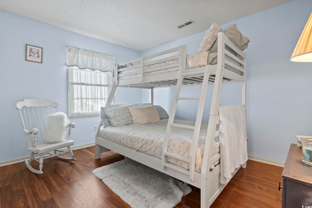 bedroom featuring a textured ceiling and dark hardwood / wood-style floors